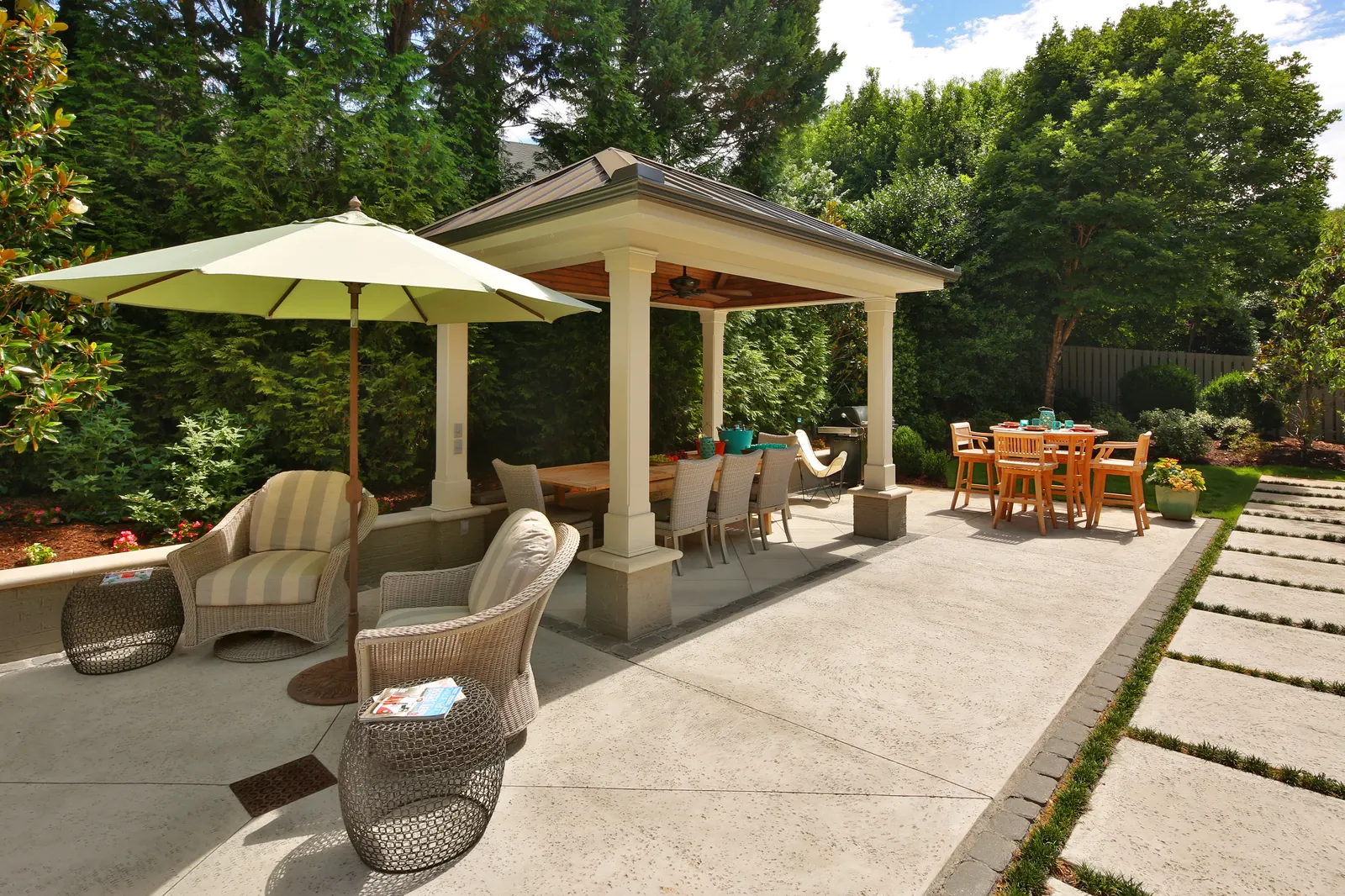 Concrete pool deck and patio with covered outdoor dining pavilion