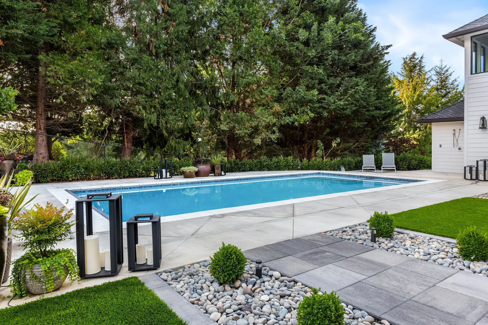 Wellness pool install with concrete pool deck and stone landscaping